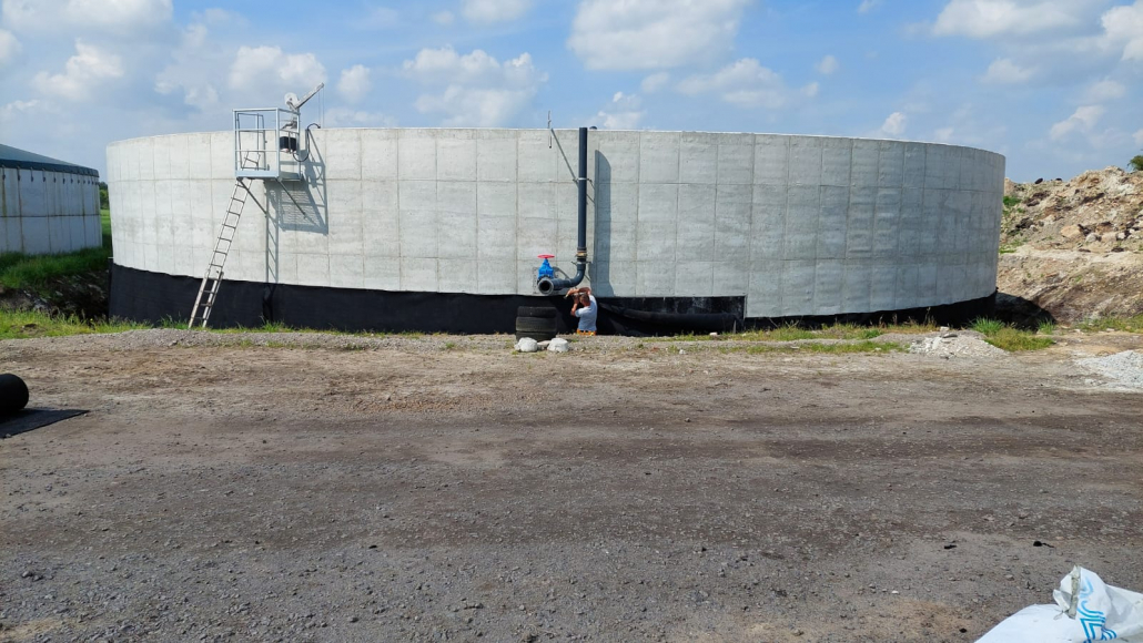 Rundbehaelter_1 Runder Behälter mit Betonwänden und schwarzer Außenabdichtung auf Baustelle.